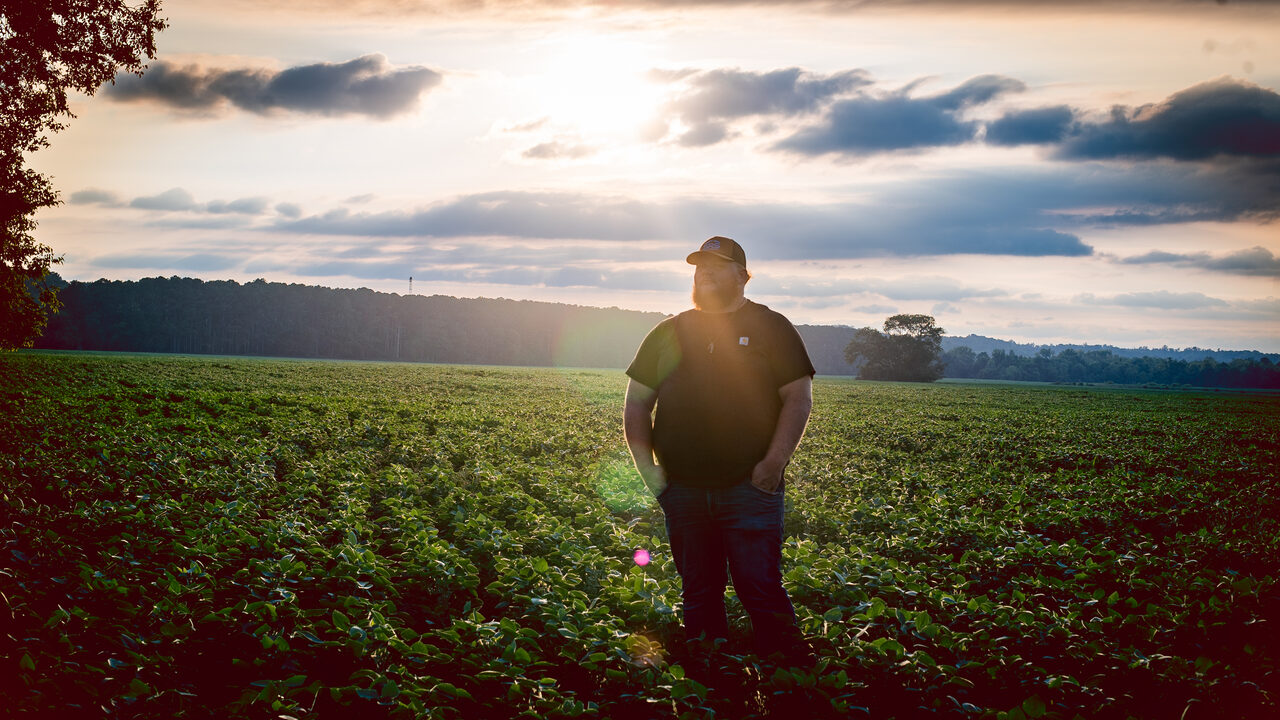 Hank Singleton standing in a farm field at golden hour