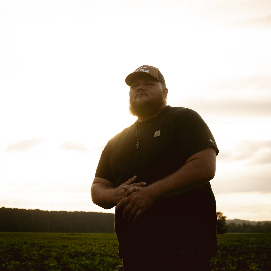 Hank Singleton standing in a field at golden hour